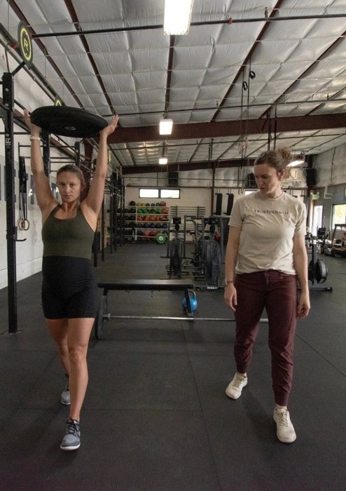 Two women training together in the gym